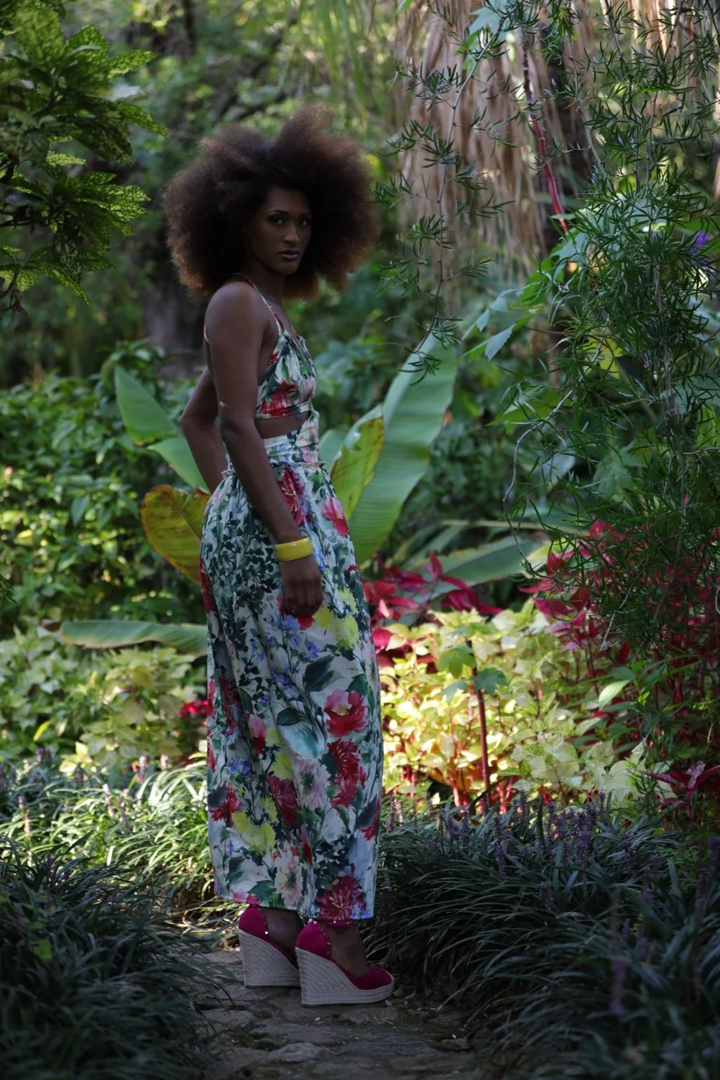 Modelo de cuerpo entero con conjunto floral en un jardín.