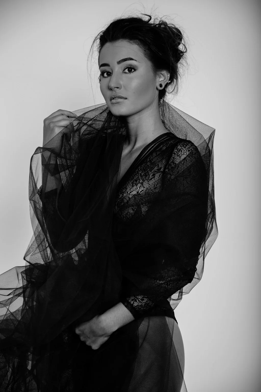Retrato en blanco y negro con encaje y tul alrededor del rostro.