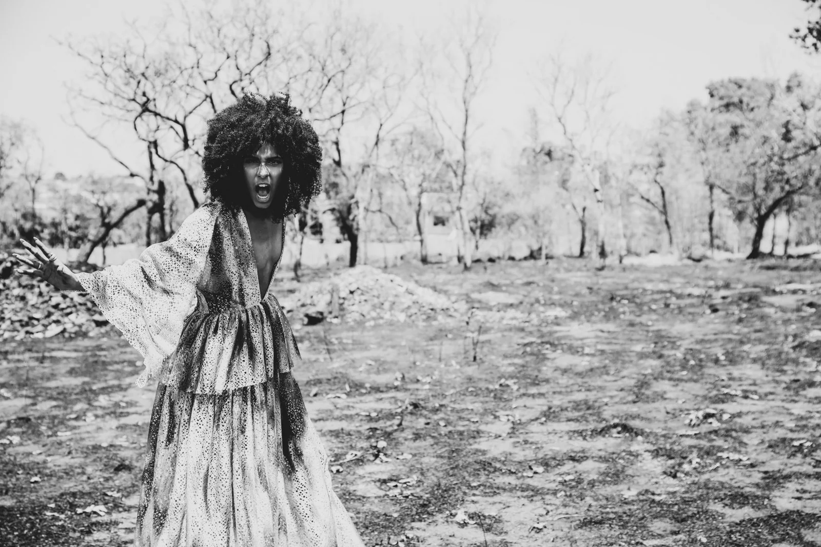 Proyecto personal en blanco y negro: modelo con vestido largo en un paisaje de árboles.