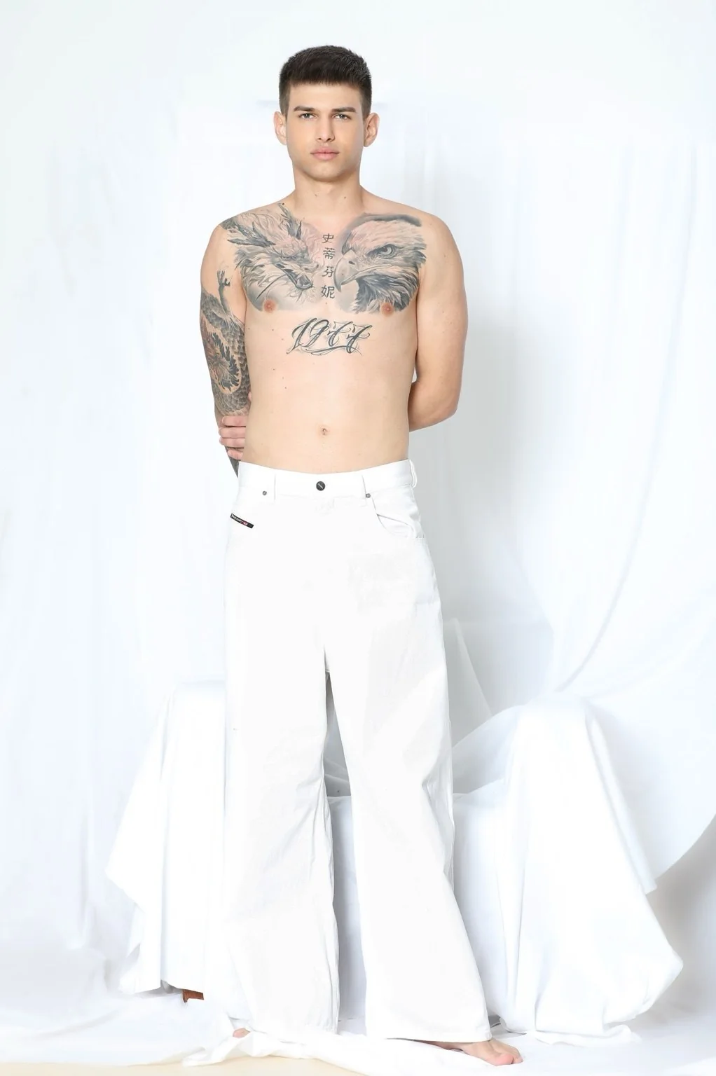 Modelo de cuerpo entero con pantalón blanco sobre fondo blanco.